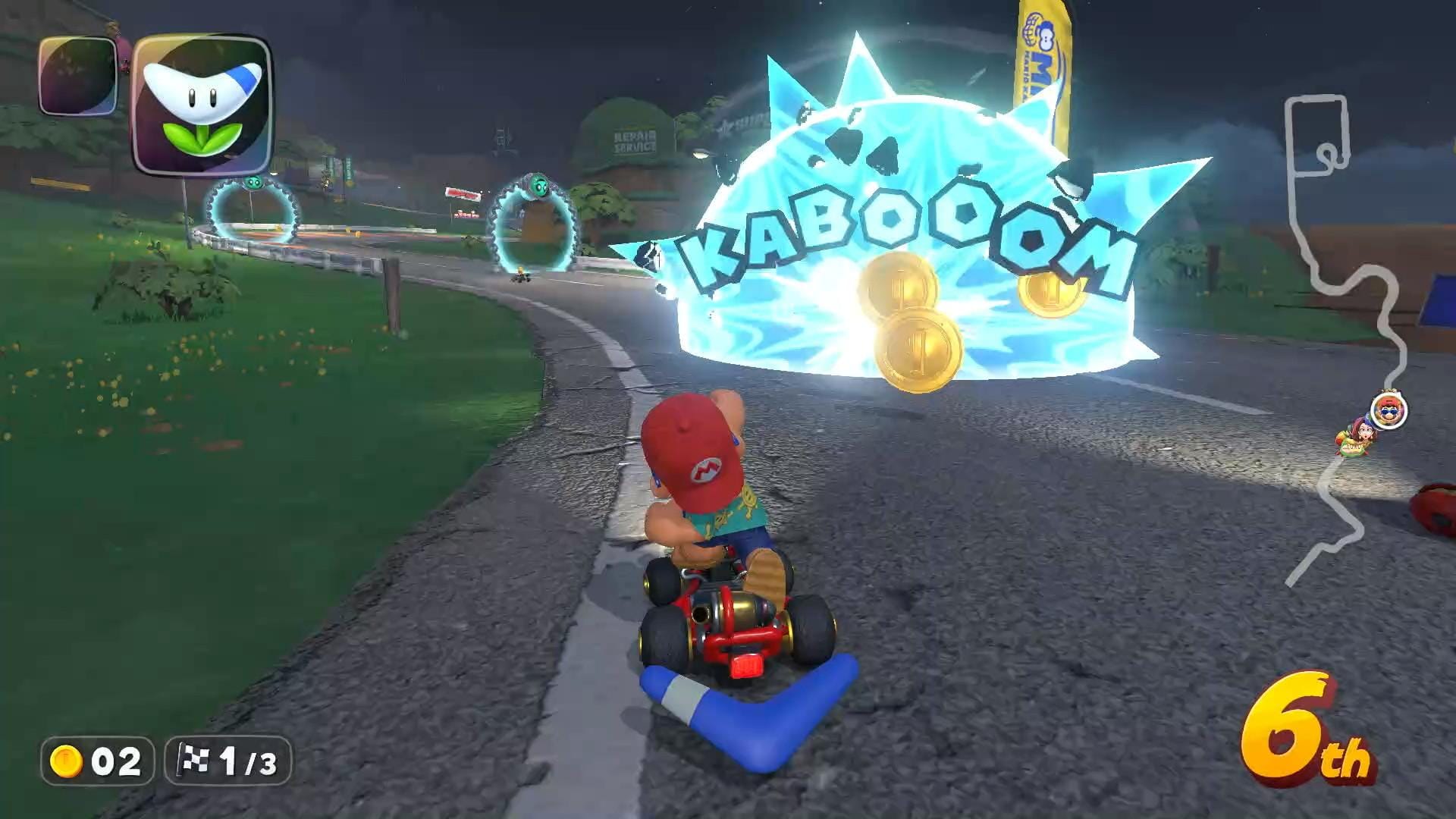 Screen shot of Mario Kart World, Mario is center screen as they race through a paved track. In front a few opponents are getting knocked out in an blue explosion with the words KABOOOM over it.